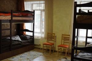 久姆里Aragats Hostel & Guest House的客房设有双层床、两把椅子和窗户。