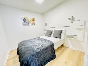 腓特烈港aday - Charming apartment in the pedestrian street of Frederikshavn的一间白色客房内的床铺卧室