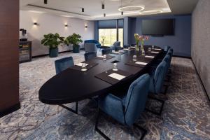 霍林赫姆Hotel Gorinchem的一间会议室,配有一张黑色大桌子和蓝色的椅子