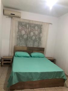 都拉斯Apartament rohelio shkembi kavajes的一间卧室配有一张带蓝色床单的床和一扇窗户。
