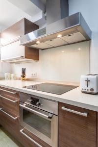 瓦伦西亚Precioso piso moderno: Terraza, A/C, NetFlix, WiFi的厨房配有不锈钢炉灶 顶部烤箱