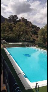 贝瑙卡斯apartamento arroyo的一个大蓝色游泳池,背景是一座山