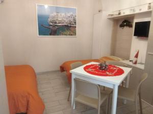 滨海波利尼亚诺GIUAMAR casa vacanza的小房间设有白色桌子和桌椅