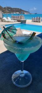 菲利普斯堡Seaview Beach Hotel的坐在游泳池旁的桌子上喝着一杯蓝色的饮料