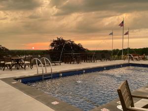 Saint ClairPINEMARK Inn Suites Events的一个带桌椅的游泳池,享有日落美景