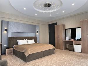 撒马尔罕阿斯多尔酒店的一间卧室配有一张大床和一个吊灯。