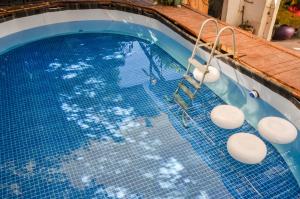拉巴斯Sunset Hostel的一个带蓝色瓷砖地板和秋千的游泳池
