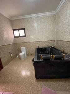 吉布提Haramous Guest House的一间带黑色浴缸和卫生间的浴室