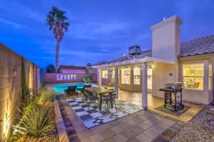 拉斯维加斯Sunset Swim - Modern Vegas Heated Pool Retreat的房屋设有带桌椅的庭院