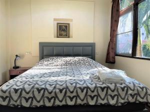 华欣Golf-Sea-City Guest House的一间卧室配有一张带黑白色棉被的床