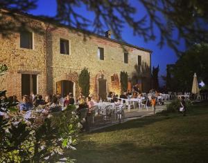 MergoAgriturismo Colle delle Stelle的一群坐在大楼前桌旁的人