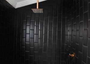 Pimville4447 Guesthouse的浴室设有黑色瓷砖墙壁和灯具
