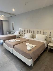 蒂加基伊琳娜海滩公寓式酒店的两张位于酒店客房的床,配有毛巾
