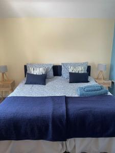 格兰瑟姆Bowtree House Bed and Breakfast的一间卧室配有蓝色的床、蓝色床单和枕头