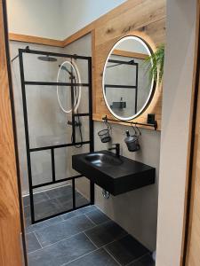 伯尼根Mountain Homes的浴室设有黑色水槽和镜子