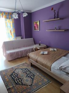 苏瓦乌基Apartament Suwalski Zakątek的一间卧室设有两张床和紫色墙壁