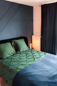 阿尔泽特河畔埃施Industrial Apartment in Belval the University City的卧室内的一张带绿色棉被的床