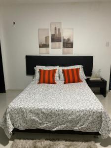 卡利El Rincón de Granada Hotel的一间卧室配有带两个橙色枕头的床