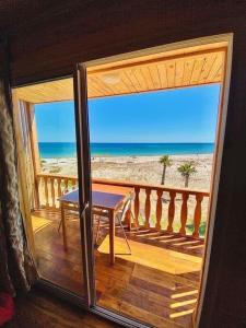 古莱比耶Kélibia beach chalets的阳台配有桌子,享有海滩美景