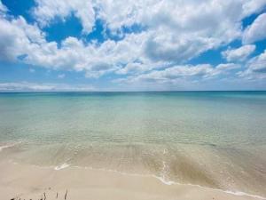 古莱比耶Kélibia beach chalets的一片拥有大海、蓝天和云的海滩