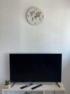 加来Appartement Calais Nord的电视机上方白色墙上的时钟