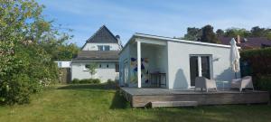 格拉尔-米里茨Ferienwohnung BROMBEERE mit großem Garten und Balkon的白色的小房子,配有甲板和两把椅子