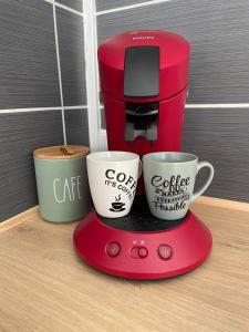 加来Appartement Calais Nord的红色咖啡壶和两个咖啡杯