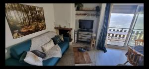 圣拉里苏朗Refuge St Lary的带沙发和电视的客厅以及阳台。