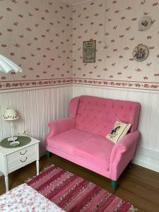 玛丽港Strandbergs Stugor的一张位于房间的角落的粉红色沙发