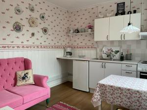 玛丽港Strandbergs Stugor的厨房配有粉红色的椅子和桌子
