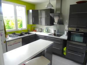 比赞诺Chambre et salle de bain de privée proche de Pau的厨房配有黑色橱柜和白色台面