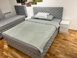 KaraburmaKoTa apartmani Beograd的一张位于带灰色床架的房间的床位