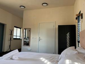 玛尔盖姆拉בסנדלים: חאן בוטיק בגולן的卧室配有白色的床和门
