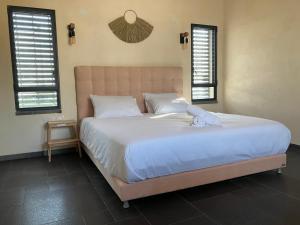 玛尔盖姆拉בסנדלים: חאן בוטיק בגולן的卧室设有一张大床,设有两个窗户