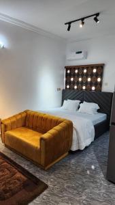 哈科特港Keev Homes & Apartments Shortlet的一间卧室配有一张大床和真皮沙发