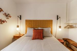 Cortes do MeioCasa do Baloiço的卧室配有白色的床和红色枕头