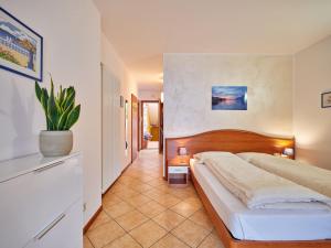 马尔切西内Appartamenti La Perla的一间卧室配有一张床和盆栽植物