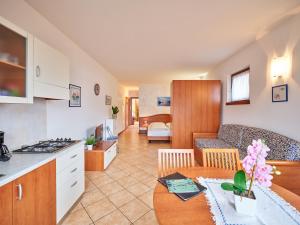 马尔切西内Appartamenti La Perla的厨房以及带沙发和桌子的客厅。