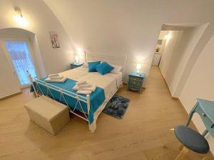 洛科罗通多La Dimora nel Borgo的一间卧室配有一张带蓝色枕头的大床