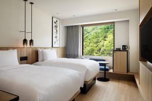串本町Fairfield by Marriott Wakayama Kushimoto的配有窗户的酒店客房内的两张床