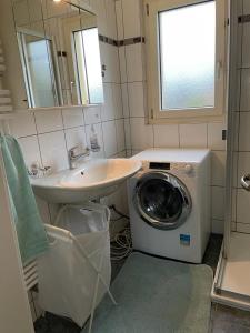 穆尔滕Appartement de 3 pièces, dans la maison familial à Morat-Murten, Fribourg-CH的一间带水槽和洗衣机的浴室