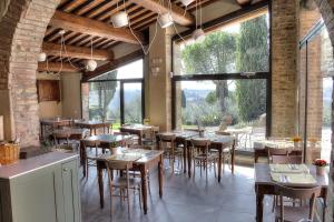 瓦尔的圣卡西亚诺萨尔瓦多妮卡酒店的餐厅设有桌椅和大窗户。