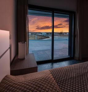 维拉多比斯坡Sunset House的一间卧室设有一张床和一个美景窗户。