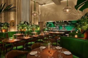 坦帕The Tampa EDITION的餐厅设有木桌和绿色椅子