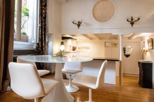 里昂美美里昂酒店的一间配备有白色桌椅的用餐室