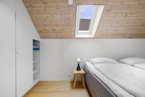斯塔万格Charming Rooftop Apartment in Heart of Stavanger的卧室配有白色的床和窗户。