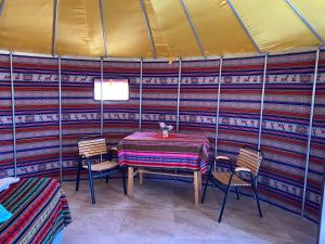 圣佩德罗·德·阿塔卡马Altos de Quitor , Glamping的帐篷内的用餐室配有桌椅