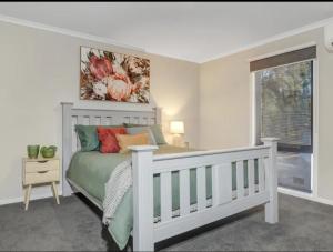 默立基Sawmill Chalet的卧室配有白色的床和窗户。