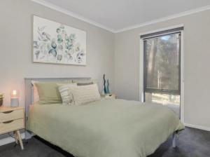 默立基Sawmill Chalet的白色的卧室设有床和窗户