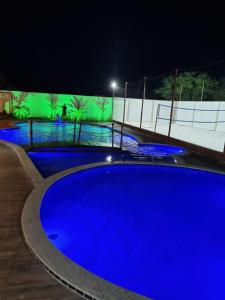皮拉尼亚斯PIRANHAS HOTEL的夜间大型蓝色游泳池